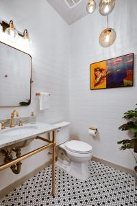 a white bathroom with a sink and a toilet at Hanger - A Birdy Vacation Rental in San Antonio +60 photos