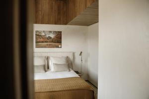 una camera da letto con un letto, pareti bianche e soffitti in legno di Soadro do Zêzere - Hotel Rural e Restaurante a Valhelhas