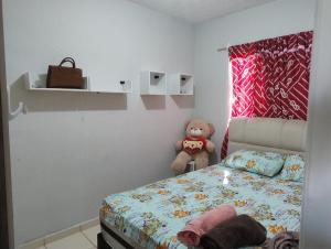 a bedroom with a bed and a teddy bear at Pedacinho do céu in Dourados