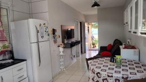 a kitchen with a table and a white refrigerator at Pedacinho do céu in Dourados +10 photos