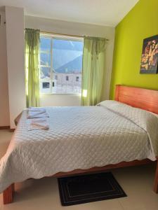 a bedroom with a large bed with a window at Amazing Home - Habitación Triple in Baños