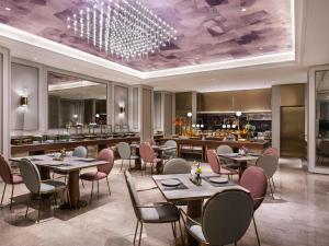 a restaurant with tables and chairs and a bar at Mercure Suzhou HSR New Town in Suzhou +30 photos