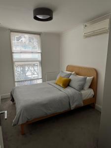 a bedroom with a bed with two pillows and a window at Modern Apartment Charing Cross - Aircon in London