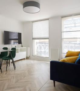 a living room with a couch and a table at Modern Apartment Charing Cross - Aircon in London
