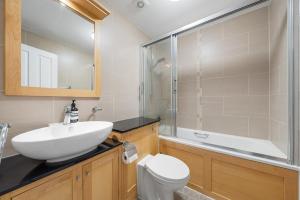 a bathroom with a sink and a toilet and a shower at Modern Apartment Charing Cross - Aircon in London