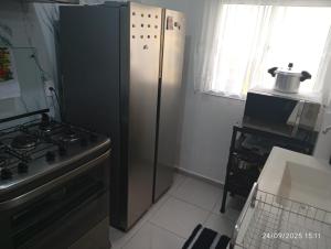 a kitchen with a refrigerator next to a stove at Meu Cantinho in Botucatu