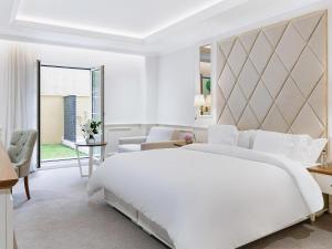 a white bedroom with a large bed and a large window at Heritage Grand Perast By Rixos in Perast +257 photos