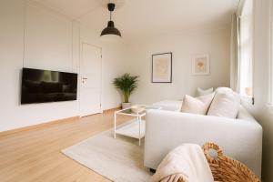 a living room with a white couch and a table at Central & Quiet by Bryggen - Minimum Age 25 in Bergen
