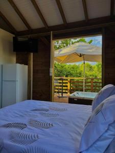 サンタンヌにあるLa pause verte bungalowの傘付きの青いベッドのある寝室