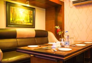 a dining room with a table and a painting on the wall at Hotel O Blue Diamond Hotel And Restaurant in Hugli