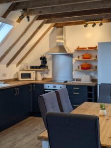 a kitchen with blue cabinets and a wooden table at Tomnauld Farm Wellness Cottage in Pitlochry