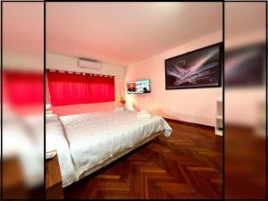 Un dormitorio con una cama y una cortina roja. en Gran monoambiente en centro de Buenos Aires (1C), en Buenos Aires