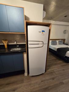 a refrigerator in a kitchen next to a bed at Conforto no Largo do Arouche 77 c Varanda, Lazer e Vista A 250m do Metrô in São Paulo