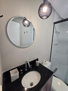 a bathroom with a sink and a mirror at Conforto no Largo do Arouche 77 c Varanda, Lazer e Vista A 250m do Metrô in São Paulo