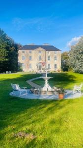 a building with a fountain and two benches in a yard at Lissanisky House in Ballymackey