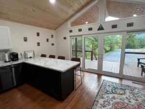 Ruth's Place Tiny Home Retreat 1 mile to town في Burnsville: مطبخ مع جزيرة كبيرة في غرفة بها فناء