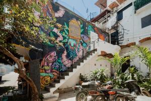 a mural on the side of a building with a motorcycle parked in front at Casa Sayula Home Cerca De Playa y Centro in Sayulita