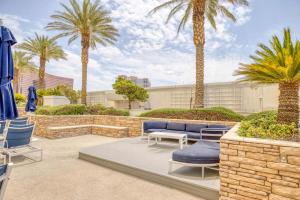 a patio with blue chairs and palm trees at Trump Deluxe Studio Mountain View in Las Vegas
