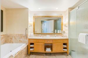 a bathroom with a tub and a sink and a mirror at Trump Deluxe Studio Mountain View in Las Vegas +28 photos