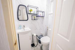 カーディフにある6 Beds House with Free Parking, Garden & Fast WiFiの洗面台とトイレを備えた白いバスルーム +21枚の写真