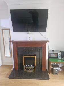 a fireplace with a television on top of it at GG drive in Lucan
