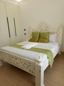 a white bed with green pillows in a bedroom at Johari One Bedroom 11th Floor Apartment-Lavington in Nairobi