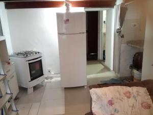 a kitchen with a white refrigerator and a stove at Flet Beira Mar in Rio de Janeiro