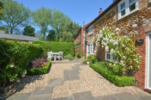 a garden with a table and a building at Rose Cottage in Sedgeford