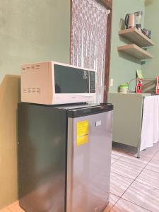 a microwave sitting on top of a refrigerator at Rous place# 2 in Fortuna +7 photos