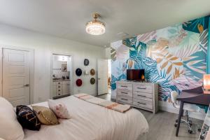 a bedroom with a bed and a desk with a television at The Q - Austin Family Home - Hot Tub & Golf Sim in Austin