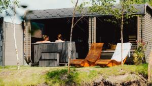 two people are in a shower in a building at Schlaffass Natursee-Chalet mit Sanitärfass in Twist +25 photos