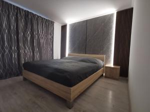 a bedroom with a bed with a black wall at Apartman Aniko in Dunajská Streda