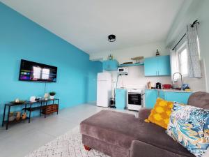 a living room with a couch and a kitchen with blue cabinets at Ocean Mist Suites in Kingstown