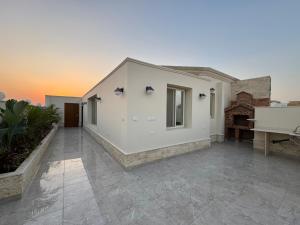 ein weißes Haus mit einer Terrasse mit einem Klavier in der Unterkunft رويال روف بالتجمع الخامس أمتداد الجامعة الامريكية in New cairo