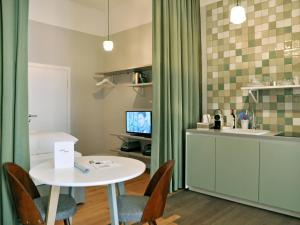 ein Wohnzimmer mit einem Tisch und einer Küche in der Unterkunft grätzlhotel Meidlinger Markt in Wien