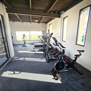 a gym with a row of treadms and cardio machines at Vane's House Consulado in Ciudad Juárez