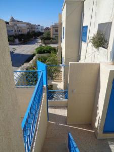 a stairway with blue railing next to a building at Maison Myriam in Nabeul