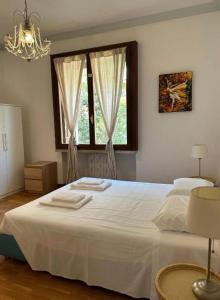 Un dormitorio con una gran cama blanca con ventana. en Marcella Grand Apartment, en Verona