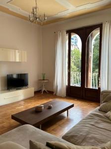 Una sala de estar con un sofá y una mesa de café. en Marcella Grand Apartment, en Verona