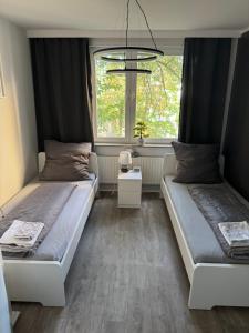 two beds in a room with a window at Emilys 3 Room Apartment 70 qm in Hannover