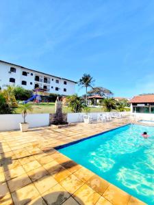 a swimming pool in front of a hotel at TOP 1 QUARTO com ESTACIONAMENTO em Condomínio com VISTA INCRIVEL - PORTARIA 24h, PISCINA, Sauna e Parquinho Infantil - Apartamento com Ar condicionado, Smart TV, Wi-Fi, Cozinha Completa, NETFLIX, Entre o MAR e a LAGOA, CUSTO BENEFICIO in São Pedro da Aldeia +35 photos