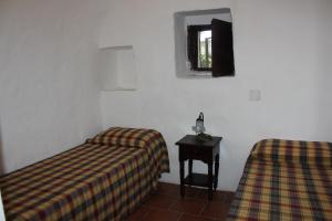 a room with two beds and a table and a window at Masseria Vagone in Macchia di Monte