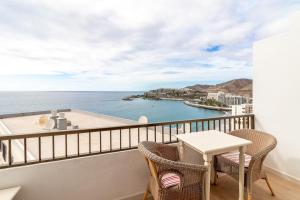 a balcony with a table and chairs and the ocean at Guaires 217 in Mogán