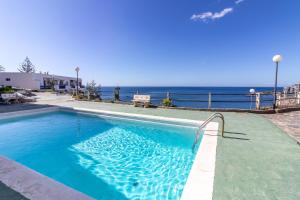 a swimming pool with the ocean in the background at Guaires 217 in Mogán