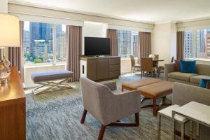 a living room with a television and a couch and chairs at The Westin Michigan Avenue Chicago in Chicago