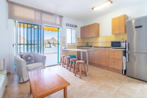 una cocina con nevera y mesa en Flatguest Namibia, en Mogán