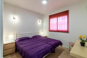 a bedroom with a purple bed and a window at Guaires 217 in Mogán +18 photos