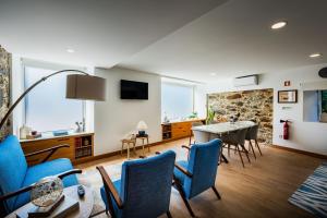 a living room with blue chairs and a table at Trilogia in Lousã