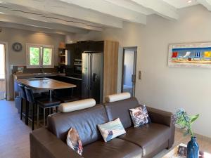 a living room with a couch and a kitchen at La Croix-Valmer, La ferme, Le Vergeron, entre terre et mer in La Croix-Valmer