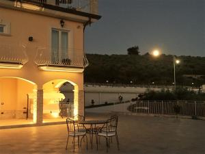 a patio with a table and chairs in front of a building at Villa Marchesa in Castelnuovo Cilento